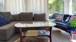 Un salon chaleureux avec un canapé, une table ronde et un tapis à motifs.