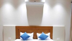 Une chambre à coucher avec une tête de lit en bois, une couvre-lit blanche et deux oreillers bleus.