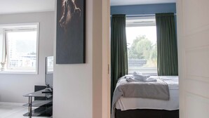 A hotel room with a bed, a desk, a chair, and a window with curtains. - Practical 3-Beds Apartment in Tromsø (Tromsø)