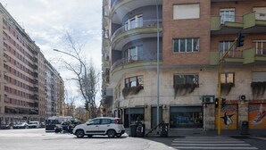 A multi-story building with balconies, a pedestrian crossing, and a traffic light. - Licia (Rome)