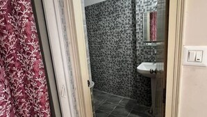 A bathroom with patterned tiles, a sink, and a mirror.
