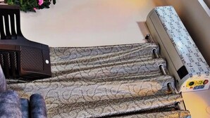 A bed with a patterned bedspread and a pillow.