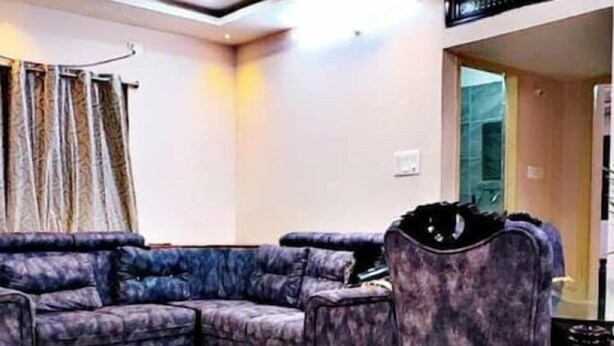 A modern living room with a sectional sofa, a single armchair, and a ceiling fan.