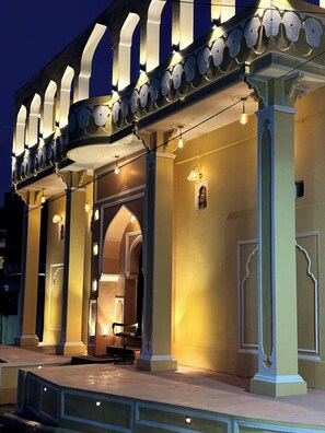 A building with a covered entrance, columns, and a seating area. - House Of Amer (Amer)