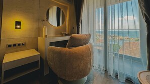 A modern bathroom with a round mirror, a towel warmer, and a view of the sea through large windows. - ASYA RESİDENCE (Sinop)