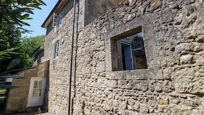 Um edifício de pedra com uma janela e uma porta.