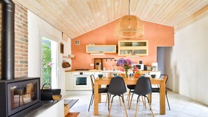 Una cocina moderna con una isla grande, techo de madera y una lámpara colgante.