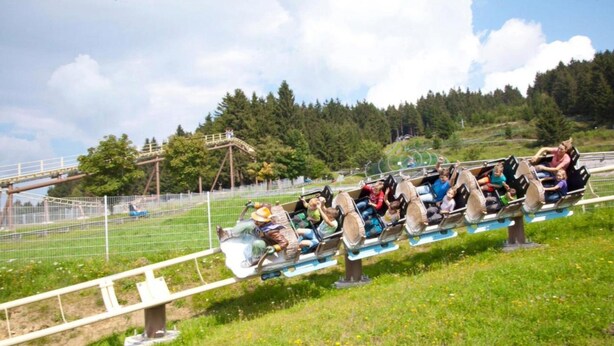 A wooden roller coaster with passengers seated in rows. - Holiday Apartment in St. Englmar (Sankt Englmar)
