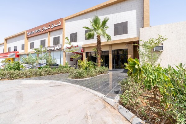 Towlan Hotel with a modern facade, a parking area, and landscaped greenery. - Towlan Al Rayan Hotel (Riyadh)