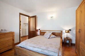 Une chambre à coucher avec un lit en bois, une commode, une table de chevet avec une lampe et une armoire.