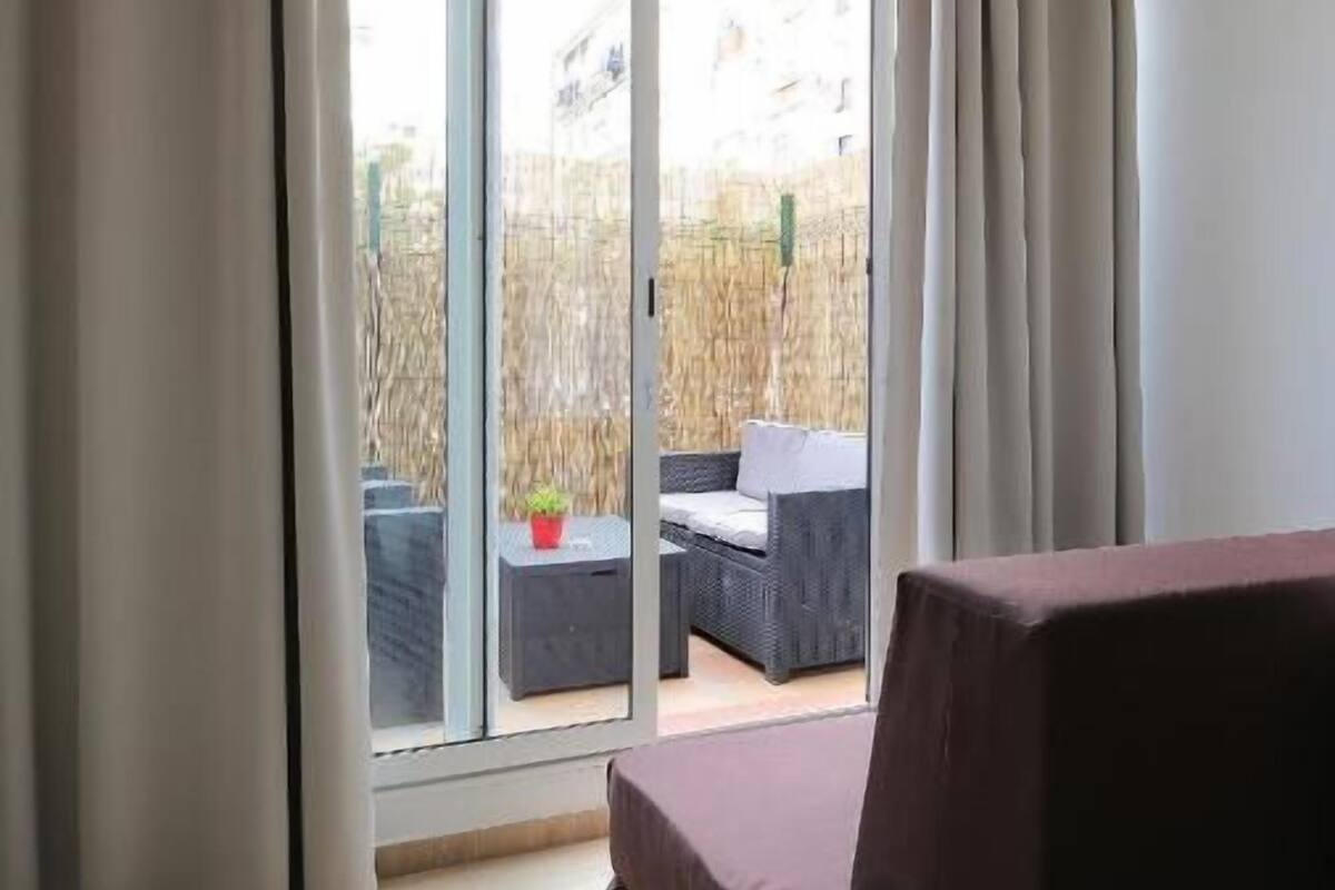 A room with a large sliding glass door leading to an outdoor area with a table and chairs.