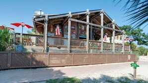 Een houten gebouw met een overdekte patio, een omheinde looppad en een bord dat aangeeft dat zwemmen verboden is.