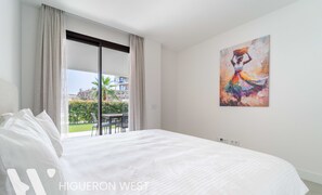 Una habitación de hotel con una cama grande, un cuadro en la pared y vistas al exterior.