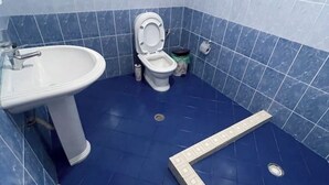 A bathroom with a white sink, toilet, and blue tiled walls. - Olympia’s Apartment – Spacious Retreat for Up to 6 Guests (Fishta)