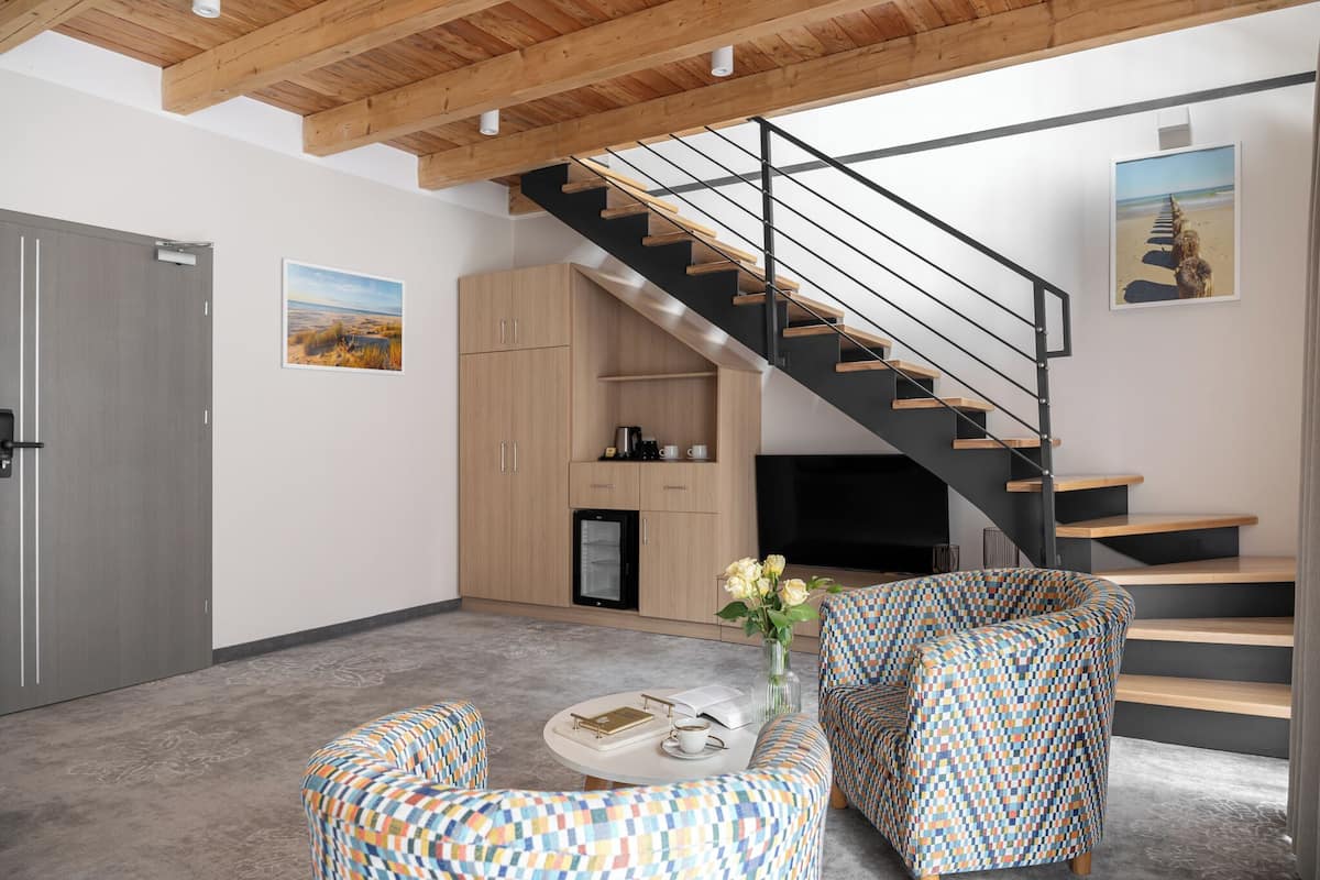 Un salon moderne avec un escalier, des meubles en bois, un téléviseur à écran plat et des meubles à motifs.