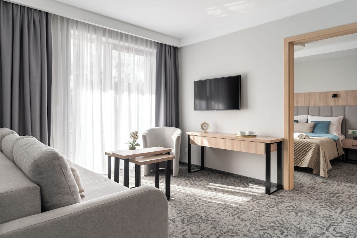 Une chambre d’hôtel moderne équipée d’un canapé, d’un bureau, d’un lit et d’une télévision.