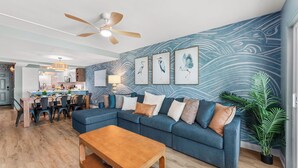 A modern living room with a sectional sofa, wooden coffee table, and a ceiling fan. - Luxury Condo-Gulf Front-Fully Loaded For Families (Panama City Beach)