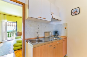 A modern kitchen with a sink, stove, and cabinets.