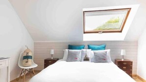 A bedroom with a large bed, a window with a view, a chair, and a nightstand. - 🏖 5 min from Bénodet and the ocean - comfortable rooms with SPA included 🌿 (Pleuven)