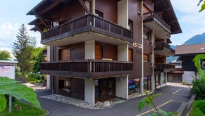 A multi-story building with balconies, a sign indicating 'La Baita', and a parking area in front. - Cosy apartment for 2 guests with WIFI, TV and balcony (Ollon)