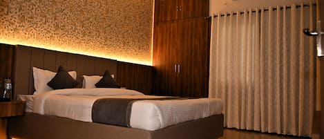 Quarto moderno com cama grande, papel de parede estampado e ar condicionado.