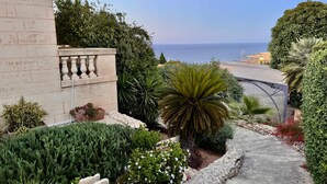 Ein angelegter Garten mit einem Weg, der zum Blick auf das Meer führt.
