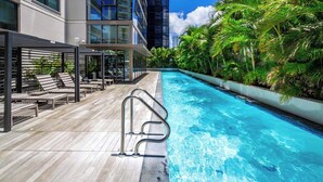 A rooftop pool area with lounge chairs and a poolside railing. - Modern 2BR at Sky Ala Moana – City & Mtn Views w/ AC/Pool/Gym/1 Parking (Honolulu)
