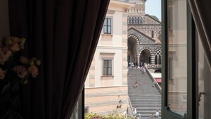 Vista de un edificio con una escalera que conduce a una entrada protegida por una verja.