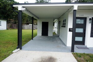 A covered porch with a concrete floor leading to a door marked "1107".