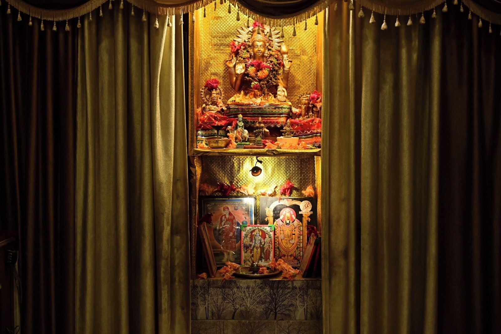 Un santuario con una estatua central, rodeado de ofrendas y decoraciones diversas.