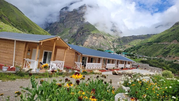 Un chalet en bois doté d’un porche abrité et offrant une vue sur un paysage montagneux.