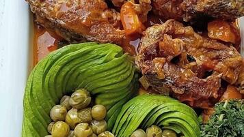 Un plato con diversos platos que incluyen carne, aguacate y verduras verdes.
