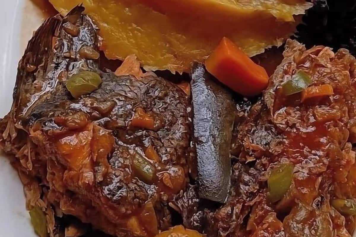 Een bord met diverse gerechten, waaronder vlees, groenten en een soort puree of saus.