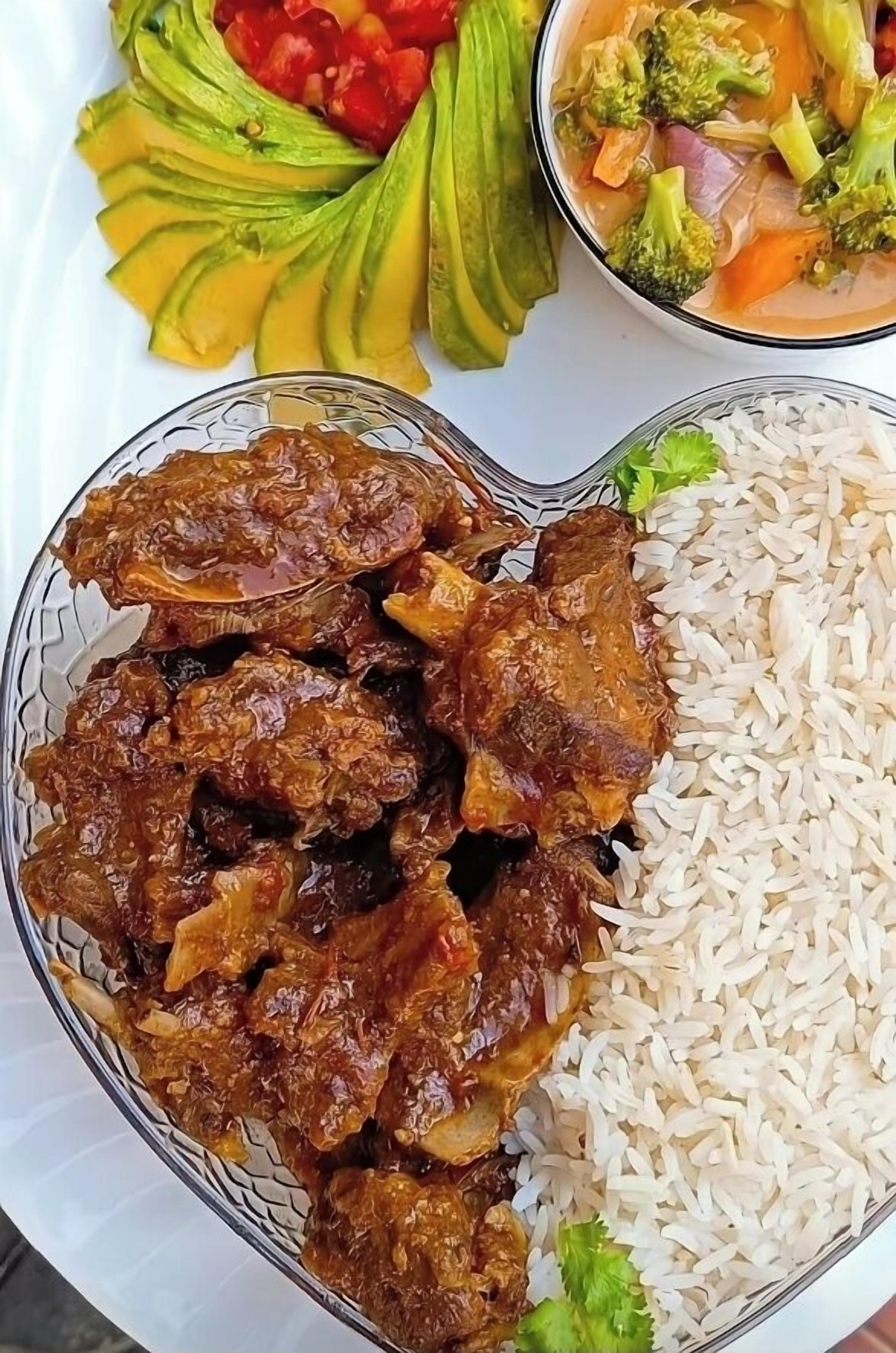 Eine Mahlzeit mit Fleisch, Reis, Avocado und einem Gemüsegericht.