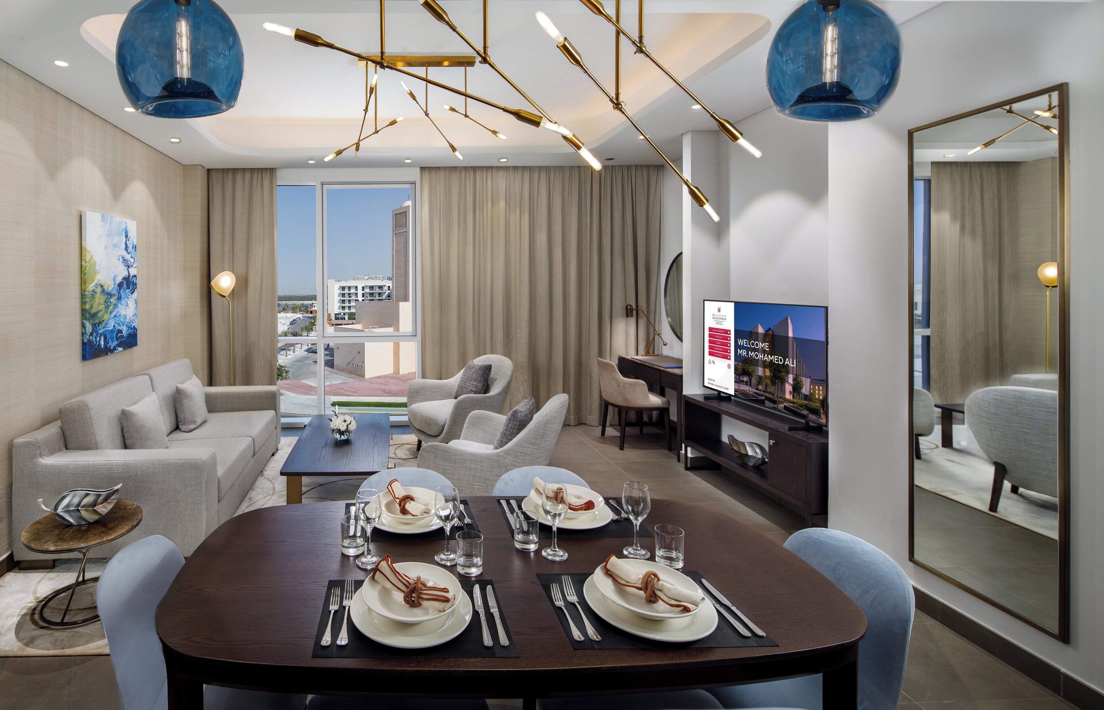 Een moderne hotelkamer met een zithoek, een bank en een televisie.