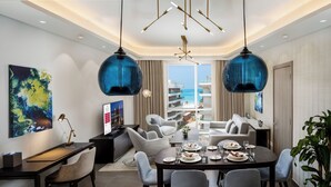 Ein moderner Essbereich mit Tisch für vier Personen, einer Couch und Blick aufs Meer.