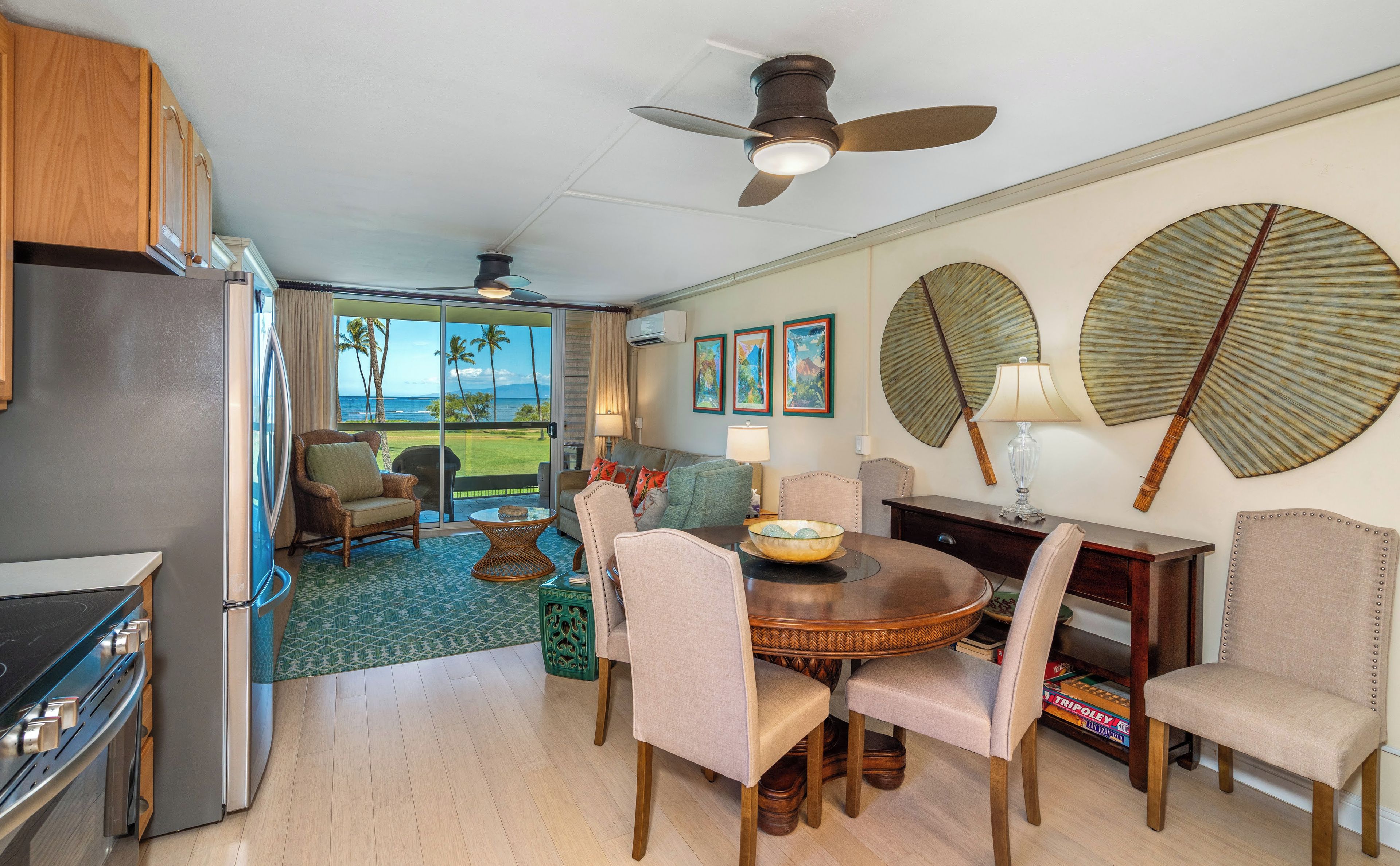 A modern kitchen with a refrigerator, stove, and dining area with chairs and a table.