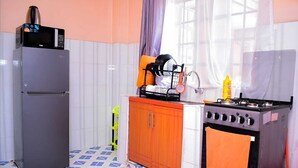 A compact kitchen with a refrigerator, a stove, and a sink.