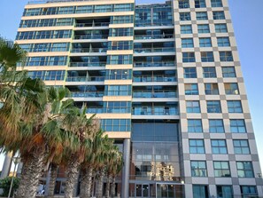 Un hotel de varios pisos con un diseño arquitectónico moderno, que cuenta con balcones en cada planta y ventanas amplias.