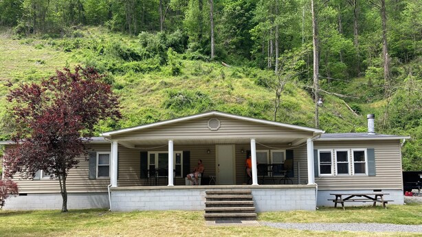 A single-story house with a porch, a picnic table, and a small outdoor area. - 3 bedroom, 3 bath home in Matewan, WV. 1 mile from the Devil Anse trailhead. (Matewan)
