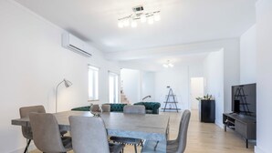 A spacious living room with a dining table, chairs, a sofa, and a TV. - Casa da Torre in Portimão (Portimão)
