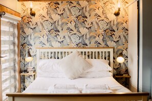 A bed with white linens, a wooden headboard, and two bedside lamps. - Corner House (Canterbury)