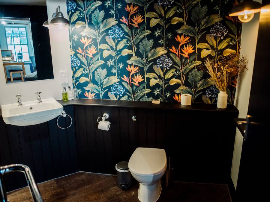 Un baño con lavamanos, inodoro y espejo.