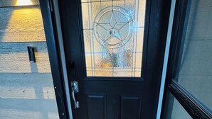 A black door with a frosted glass panel featuring a star design.