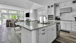 Una cocina amplia con armarios blancos, encimera de granito y una isla grande.