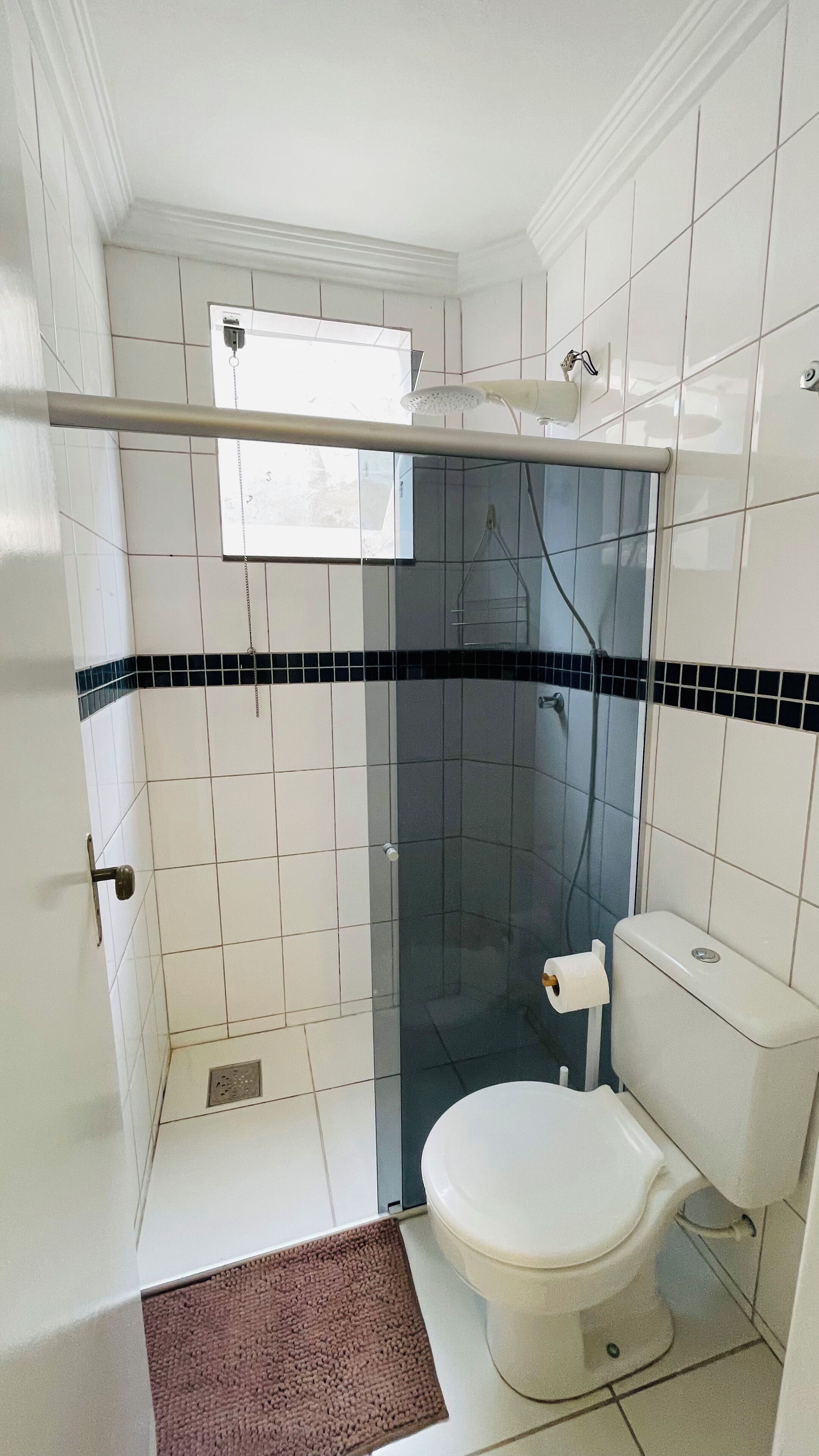 Un bagno con doccia, WC e portasciugamani.