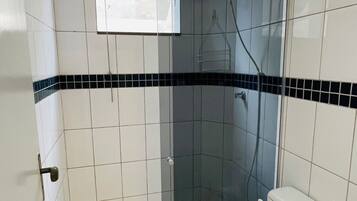 Un bagno con doccia, WC e portasciugamani.