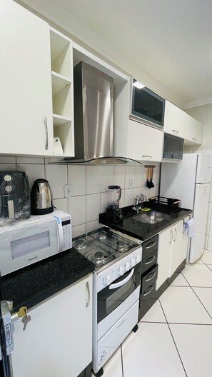 Microwave, oven, stovetop - Apartment with queen bed, smart TV, garage, air and Wi-Fi. Pets allowed (Universitário Governador Valadares)