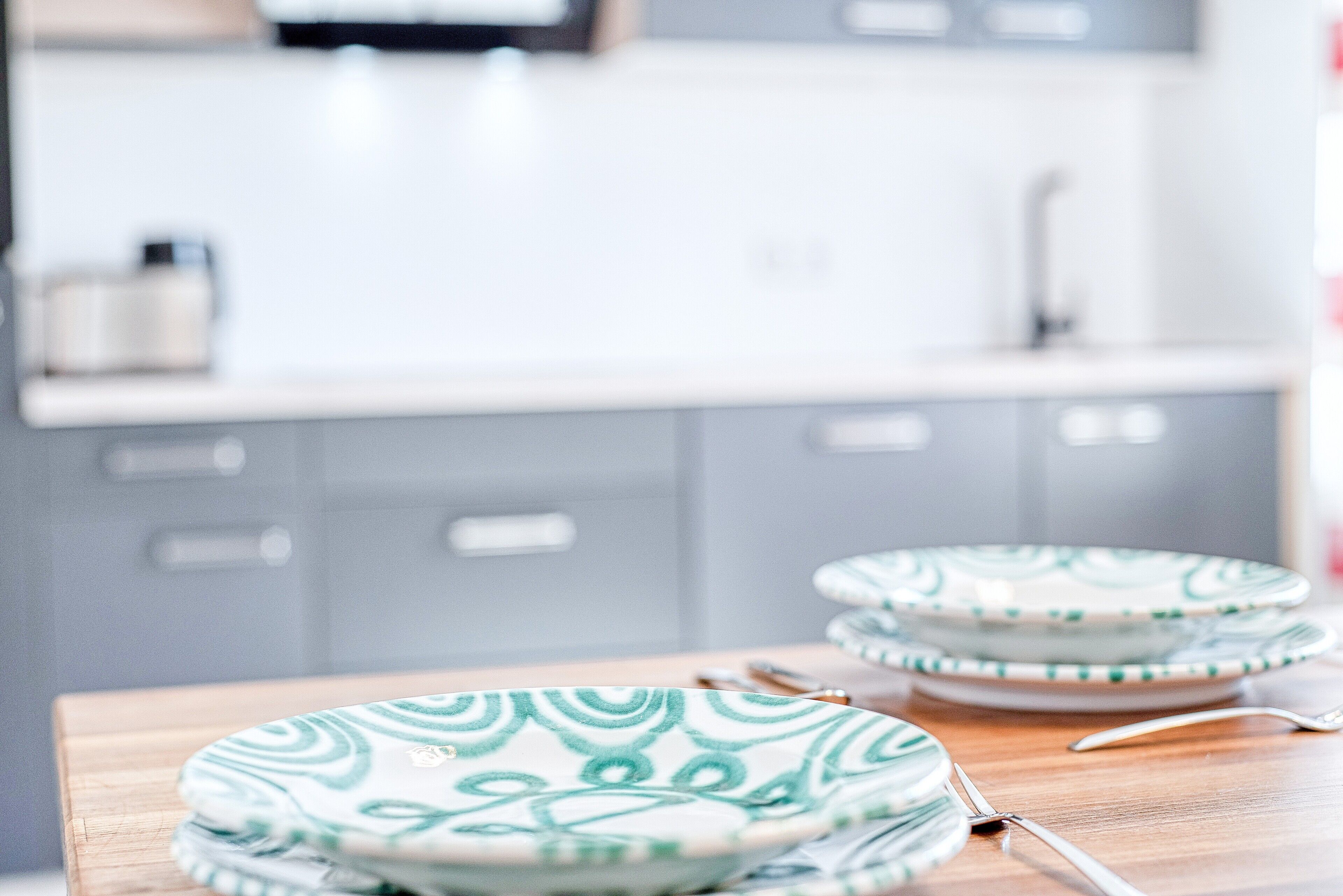A kitchen with a wooden table, a sink, and cabinets.