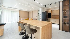 Une cuisine moderne dotée d’un îlot central, de tabourets de bar et d’un coin repas avec un canapé.